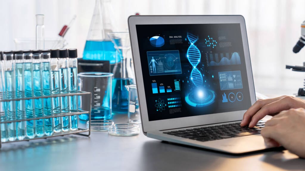 A laptop computer in a laboratory next to samples with advanced, futuristic graphics on the screen