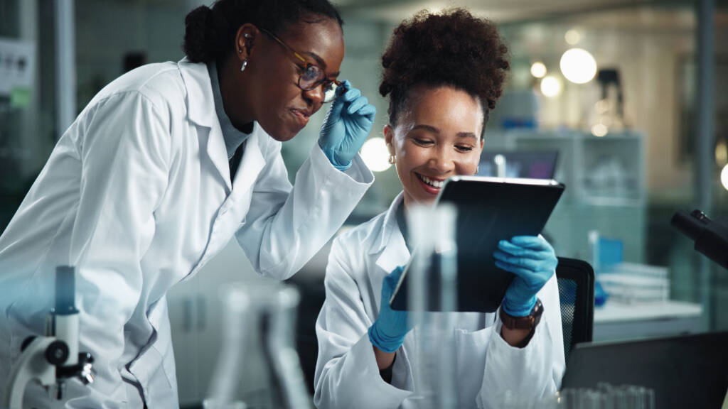 Two lab technicians reviewing data in their LIMS on a tablet - Best LIMS of 2025 Guide