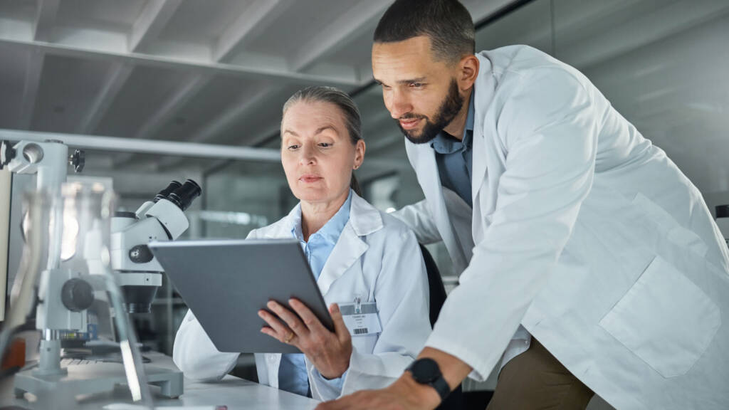 Lab techs reviewing data on a tablet within their LIMS - Best LIMS of 2025